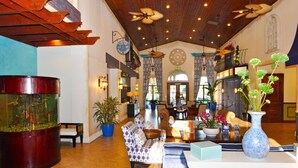 Eine großzügige Lobby mit einem großen Aquarium, bequemen Sitzgelegenheiten und Zierpflanzen.