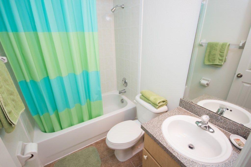 Une salle de bain avec une baignoire, des toilettes et deux lavabos.