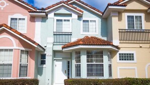 A row of townhouses with a central entrance, a small porch, and a visible mailbox. - Ip60350 - Fiesta Key - 3 Bed 2.5 Baths Townhome (Kissimmee)