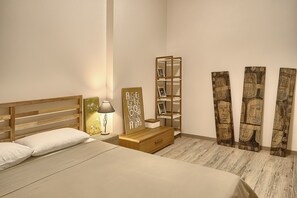 A bedroom with a bed, bedside table, lamp, and a wooden cabinet.