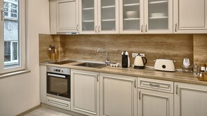 A kitchen with white cabinets, a stainless steel sink, and a built-in oven. - Baratero City II Apartment (Sofia)