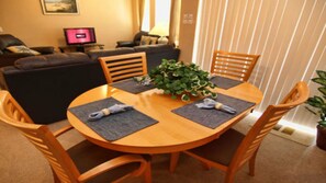 A dining area with a round wooden table, four chairs, and a potted plant. - Tr112 - Terrace Ridge - 2 Bed 2 Baths Condo (Davenport)