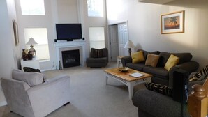 A living room with a fireplace, a television, and a sofa.