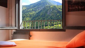 A bedroom with a view of a forested mountain. - Barri Antic Hostel & Pub (Andorra la Vella)