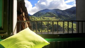 A room with a view of mountains through a window with a metal railing. - Barri Antic Hostel & Pub (Andorra la Vella)