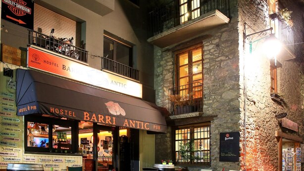 A Hostel Barri Antic Pub with outdoor seating and a stone facade. - Barri Antic Hostel & Pub (Andorra la Vella)