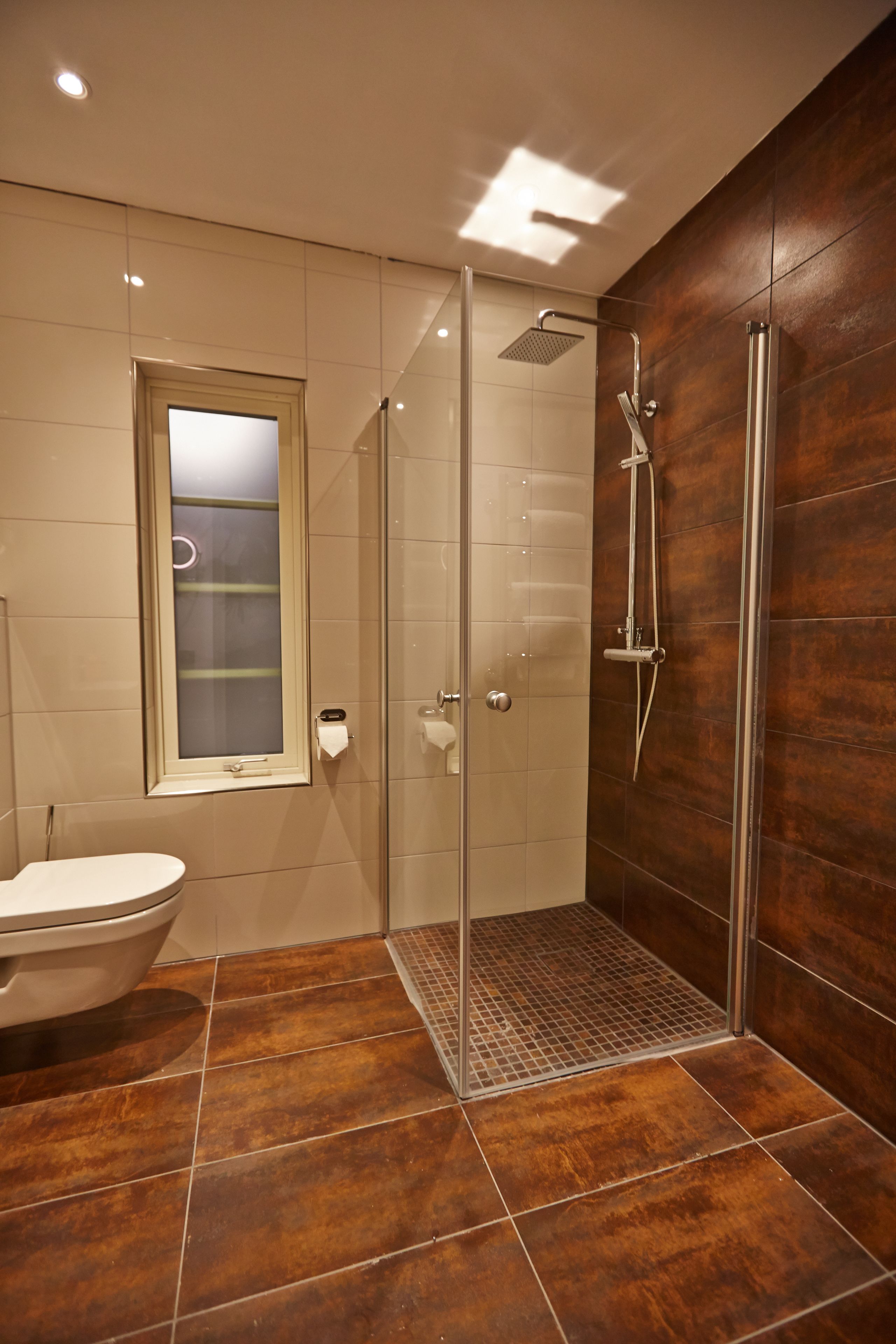 deluxe room | bathroom | shower, rainfall showerhead, hair dryer, towels