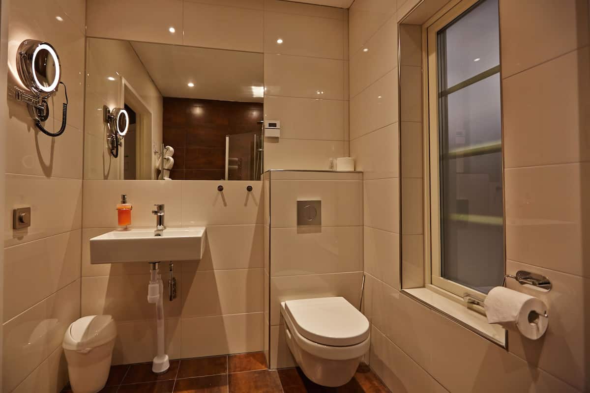 deluxe room | bathroom | shower, rainfall showerhead, hair dryer, towels