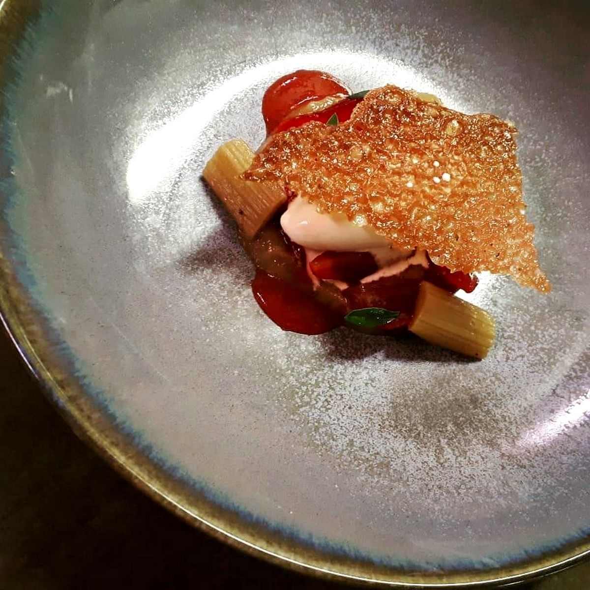 Un plato con base de pan tostado, tomates y salsa cremosa.
