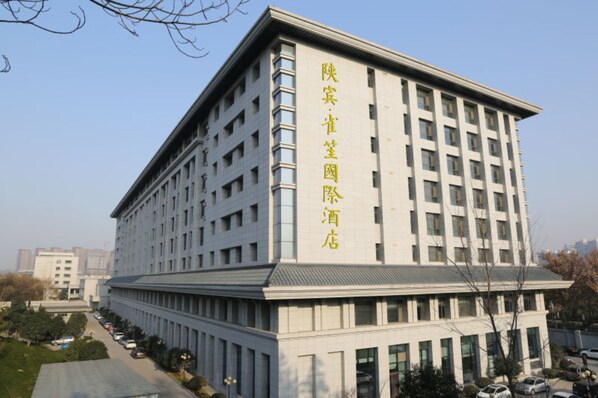 A large, multi-story building with a flat roof and a symmetrical facade. - QueenSir International Hotel (Xi'an)