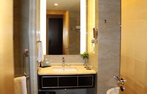 A bathroom with a large mirror, a sink, and a shower. - QueenSir International Hotel (Xi'an)