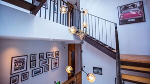 A staircase with a wooden handrail and a modern light fixture with spherical glass shades. - Maan Coco Travelling Boutique Inn (Shenzhen)