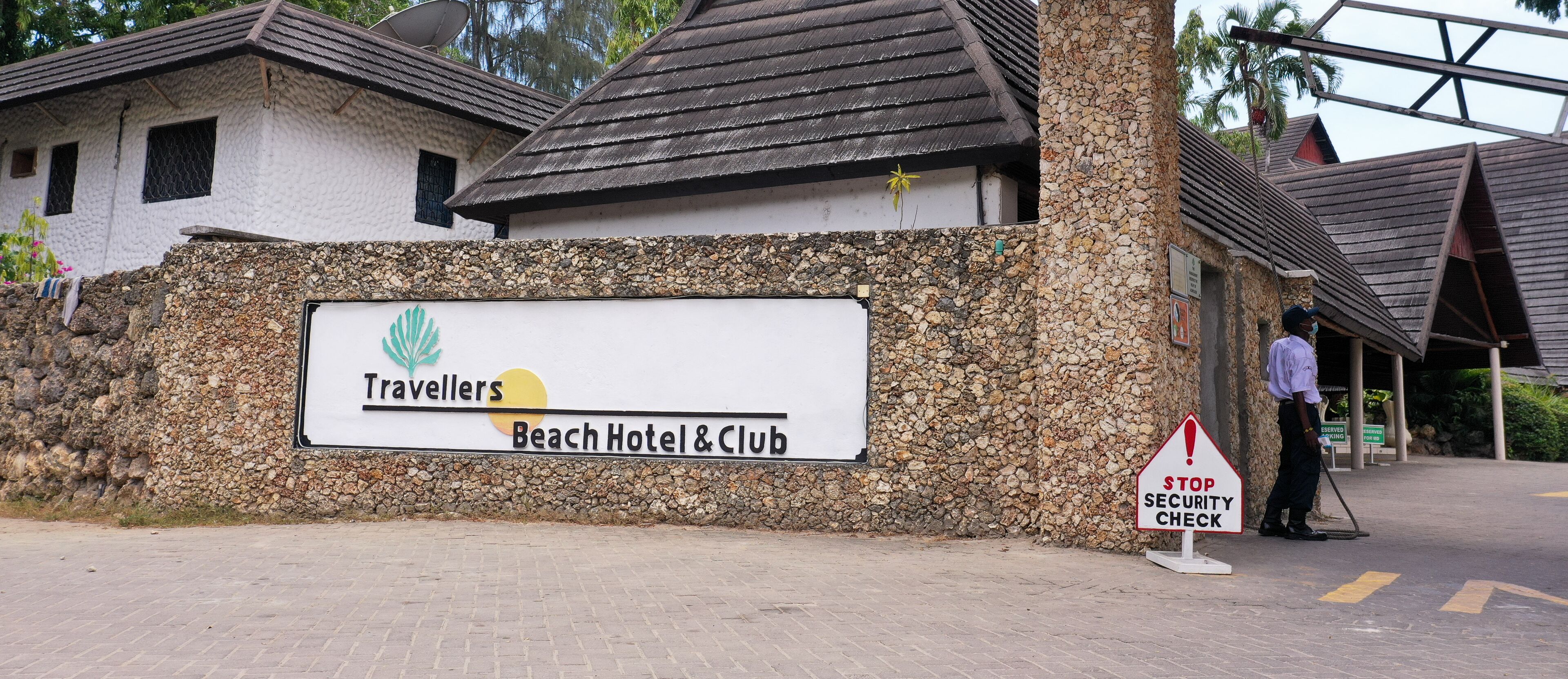 Un panneau indiquant l’hôtel et le club Travellers Beach, avec un point de contrôle de sécurité.