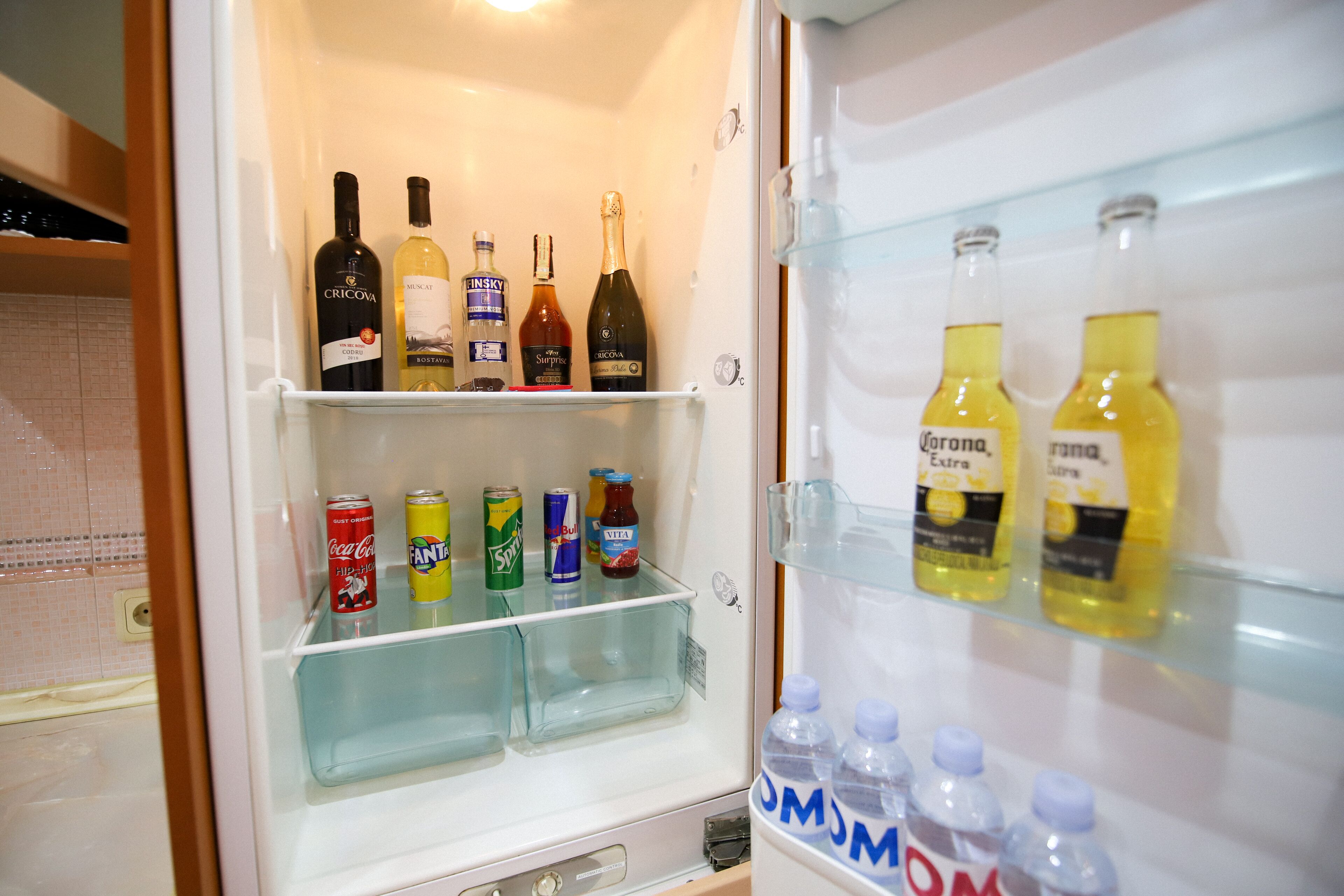 A refrigerator stocked with various beverages including wine, beer, and soda.