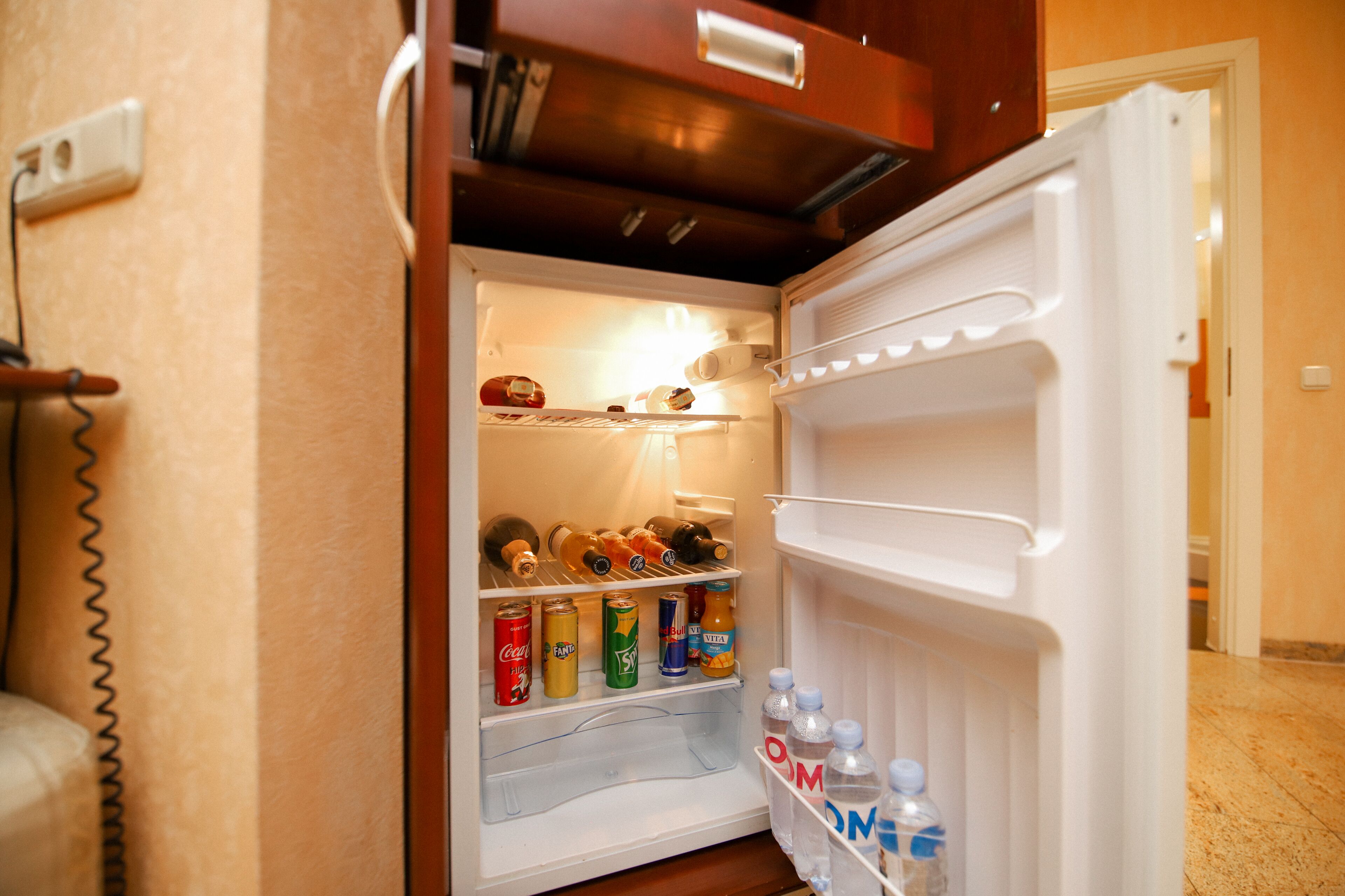 An open refrigerator stocked with beverages and snacks.