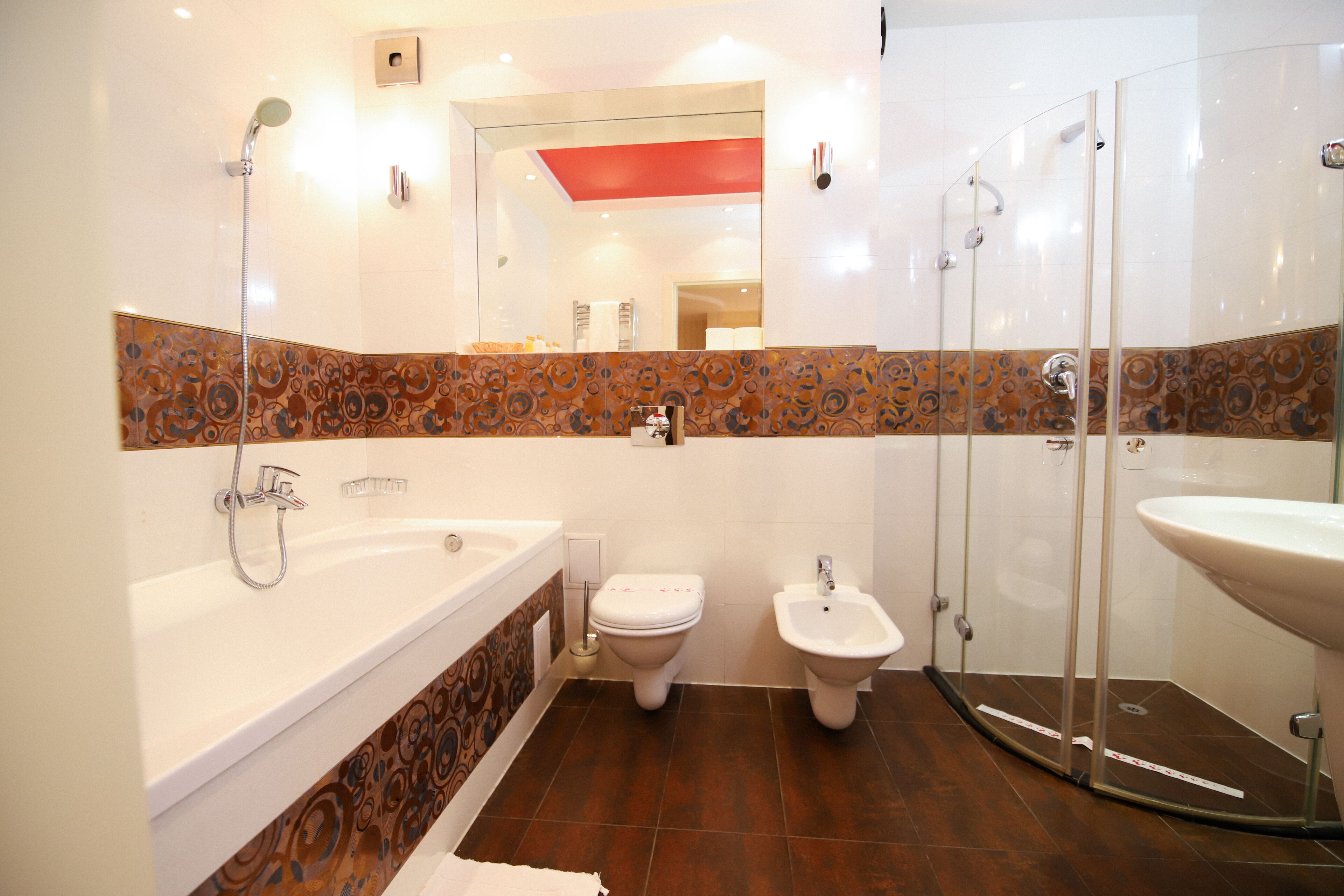 A modern bathroom with a bathtub, toilet, bidet, and glass-enclosed shower.