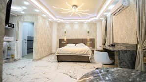A modern bedroom with a large bed, marble flooring, a built-in TV, and a ceiling light fixture. - Prestige Apart Hotel (Chisinau)
