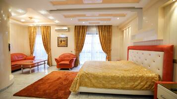 A bedroom with a bed, a sofa, a chair, and a carpet.