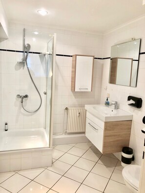 Design studio suite, 1 queensize bed | Badkamer | Een douche, gratis toiletartikelen, een haardroger, handdoeken