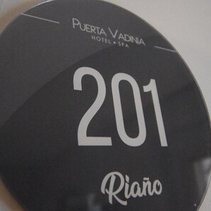 A black circular sign with the text "Puerta Vadina Hotel & Spa" and the number "201" indicating room number.