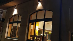 Un immeuble à plusieurs étages, doté de fenêtres illuminées et d’un balcon.
