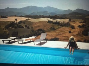 Piscina a l'aire lliure de temporada, para-sols i gandules