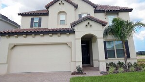 A two-story house with a beige facade, a tiled roof, and a garage. - Fv62387 - The Dales at West Haven - 7 Bed 6 Baths Villa (Davenport)