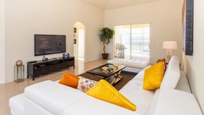 A modern living room with a white sofa, a flat-screen TV, a coffee table, and a ceiling fan. - Fv51890 - Crystal Cove - 4 Bed 3 Baths Villa (Kissimmee)