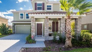 A two-story house with a garage, a front porch, and a palm tree. - Ip60500 - Solterra Resort - 6 Bed 4 Baths Villa (Davenport)