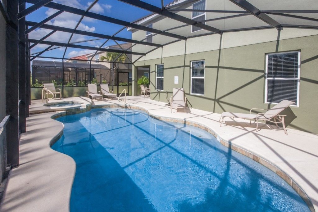 A covered swimming pool with lounge chairs and a clear view of the surrounding area.