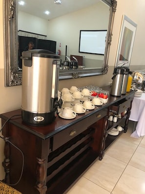 A breakfast bar with coffee makers, tea pots, and a variety of cups and saucers. - The Clan Guest House (Maseru)