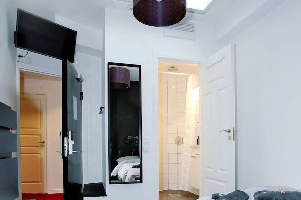 Un dormitorio con tragaluz, una cama, un aparador y un vestidor.