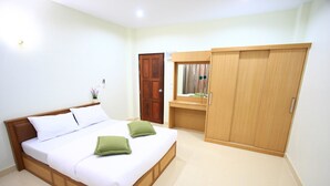 A bedroom with a wooden bed, a wardrobe, and a small desk with a mirror. - Tree House Apartment Songkhla (Songkhla)