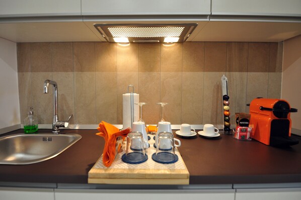 A modern kitchen with a sink, faucet, and a coffee machine. - Delco Naples (Naples)