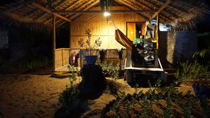 A thatched-roof hut with a small porch, a hammock, and a fire extinguisher. - Valampuri Kite Resort (Kalpitiya)