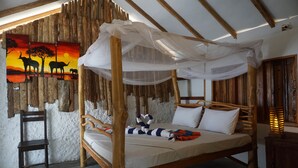 A wooden bed with a canopy, a painting of elephants, and a chair. - Valampuri Kite Resort (Kalpitiya)