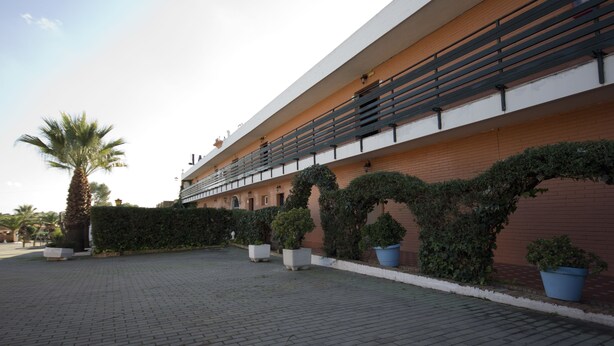 A building with a modern architectural style, featuring a flat roof and a series of balconies.