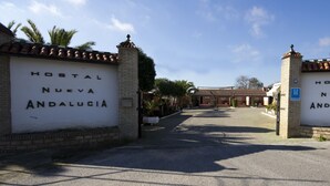 A hotel entrance with "Hostal Nueva Andalucia" signs on either side.