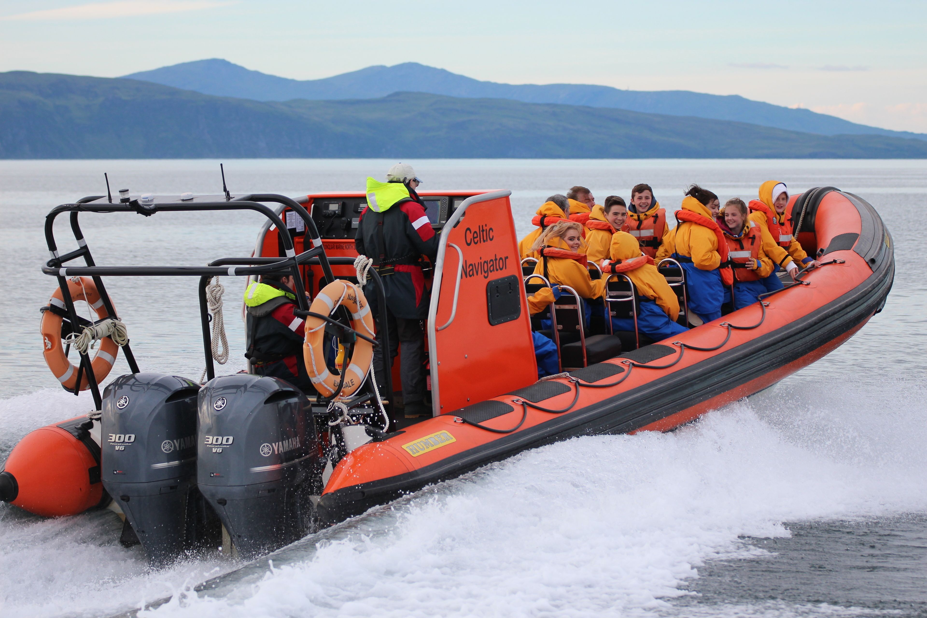 A boat with passengers wearing life jackets and a sign that reads "Celtic Navigator."