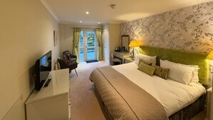 A hotel room with a bed, a desk with a computer, a chair, a TV, and a window with curtains. - The Airds Hotel & Restaurant (Appin)