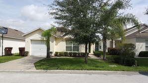 A residential street with houses, a driveway, and a basketball hoop. - Ahr225 - Southern Dunes - 3 Bed 2 Baths Villa (Haines City)