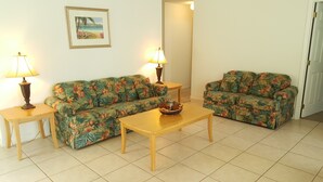 A living room with two floral sofas, a wooden coffee table, and two lamps on side tables. - Ahr225 - Southern Dunes - 3 Bed 2 Baths Villa (Haines City)