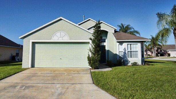 A single-story house with a garage, a small porch, and a well-maintained lawn.