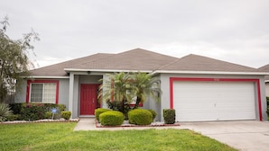 A single-story house with a red front door, a garage, and a well-maintained lawn. - Ip60285 - Hillcrest Estate - 4 Bed 3 Baths Villa (Davenport)
