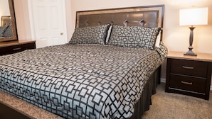 A neatly made bed with a patterned bedspread, a headboard, a bedside lamp, and a nightstand with drawers. - Ip60285 - Hillcrest Estate - 4 Bed 3 Baths Villa (Davenport)