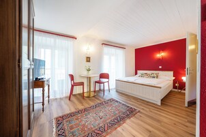 Un dormitorio con una cama, dos sillas, una mesita y una alfombra.