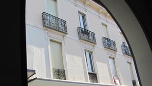 Un edificio con varios balcones, amplias ventanas y una entrada central con columnas.