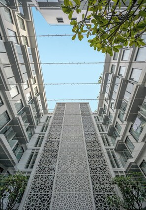 Un edificio moderno con fachada geométrica y un panel decorativo central.