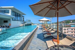 Una piscina al aire libre, sillones reclinables de piscina