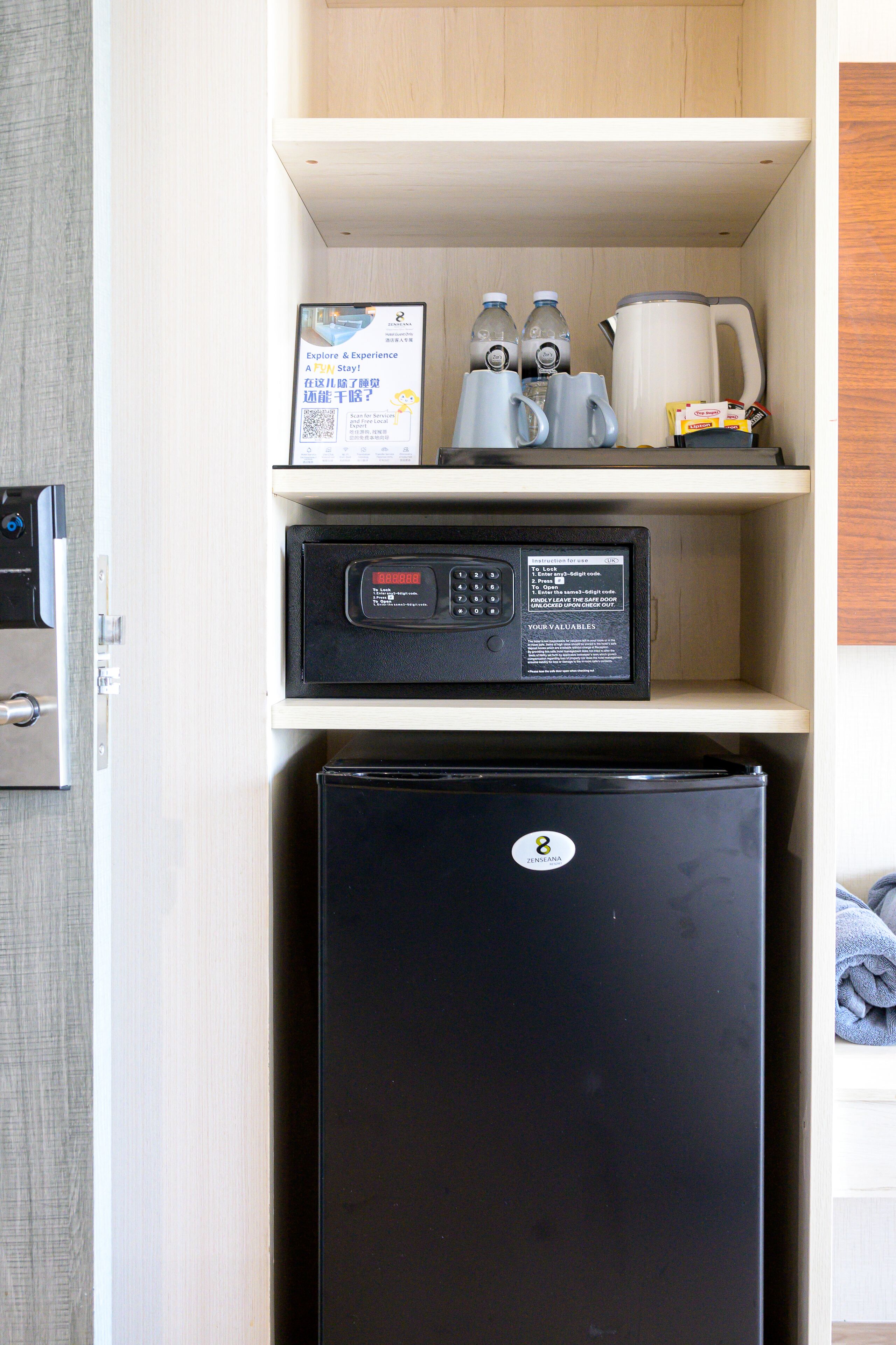 A compact kitchenette with a refrigerator, a coffee maker, and a microwave.